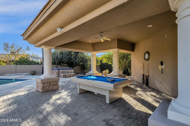 view of patio with ceiling fan and a swimming pool with hot tub