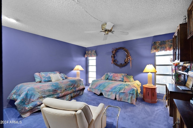 carpeted bedroom with ceiling fan, multiple windows, and a textured ceiling