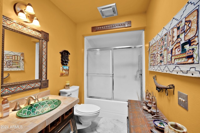 full bathroom featuring vanity, shower / bath combination with glass door, and toilet