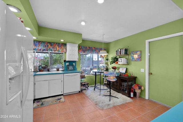 kitchen featuring light tile patterned flooring, pendant lighting, white cabinetry, sink, and white appliances