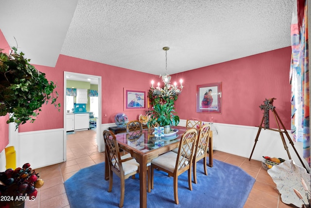 dining area featuring light tile patterned flooring, a textured ceiling, and a chandelier