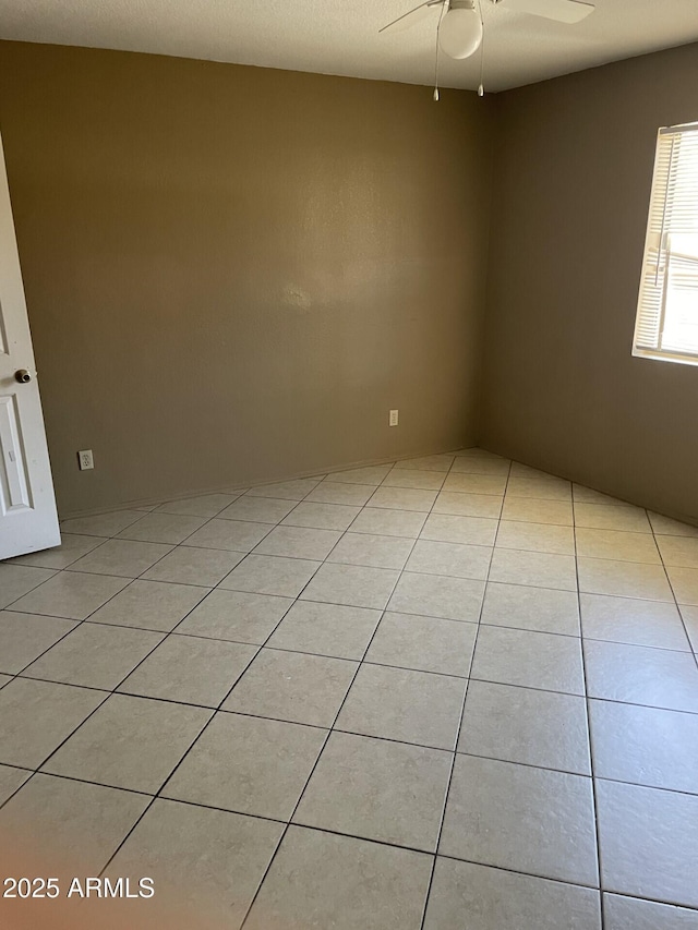 unfurnished room featuring light tile patterned floors and ceiling fan