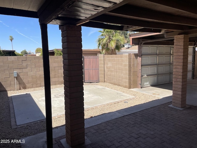 view of patio / terrace featuring a garage and fence