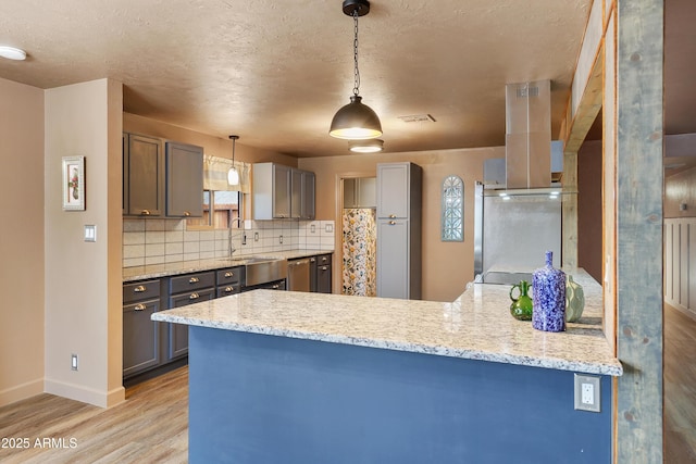 kitchen with pendant lighting, sink, tasteful backsplash, and kitchen peninsula