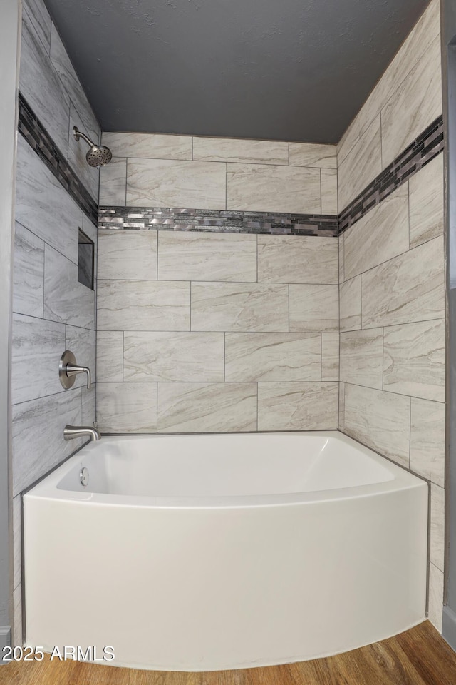 bathroom featuring hardwood / wood-style floors and tiled shower / bath