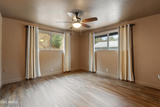 unfurnished room featuring a healthy amount of sunlight, a textured ceiling, and light wood-type flooring