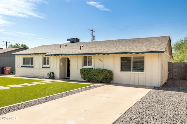 ranch-style home with cooling unit and a front lawn