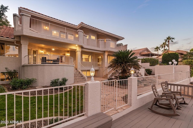 deck at dusk featuring a yard