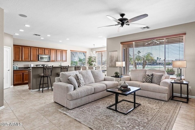 tiled living room with a textured ceiling and ceiling fan