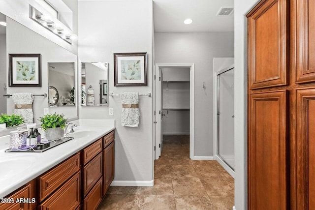 bathroom featuring vanity, a shower with shower door, and tile patterned flooring