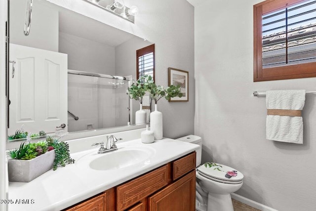 bathroom featuring vanity, toilet, and a shower with shower door