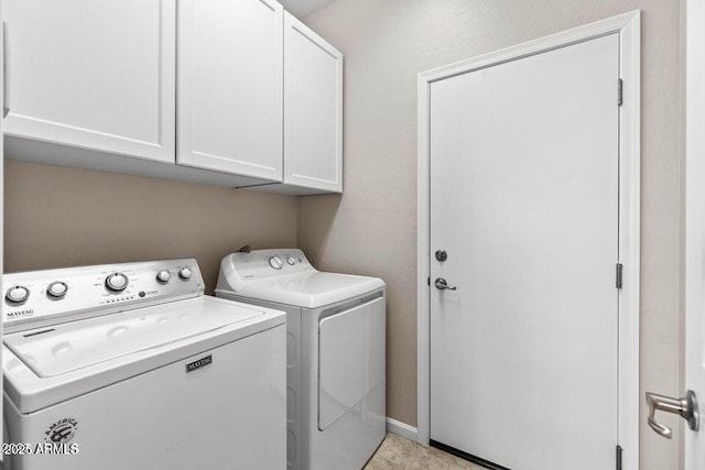 washroom with washer and dryer and cabinets