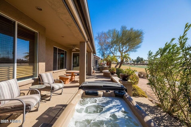 view of patio / terrace with a hot tub and ceiling fan