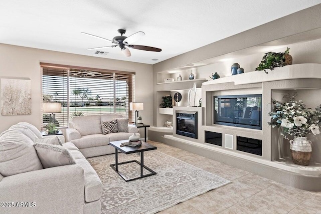 tiled living room with built in features and ceiling fan