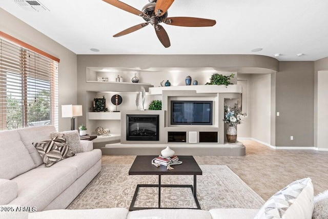 living room with ceiling fan and built in features