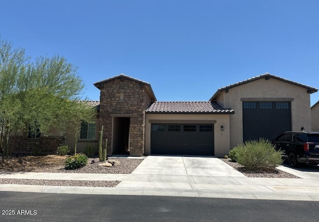 7563 W Electra Ln, Peoria, AZ 85383 - view of front facade featuring an attached garage, stucco siding, a tile roof, concrete driveway, and stone siding