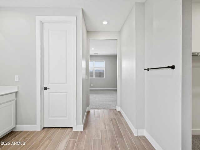 bathroom featuring wood finish floors, vanity, and baseboards