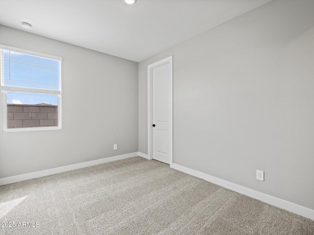 carpeted spare room with baseboards