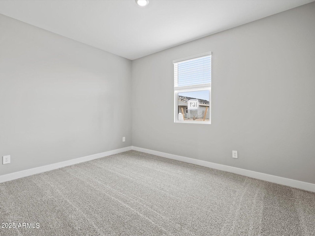 empty room featuring carpet and baseboards