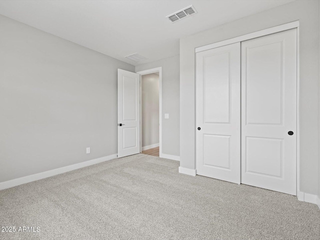 unfurnished bedroom featuring carpet floors, baseboards, visible vents, and a closet