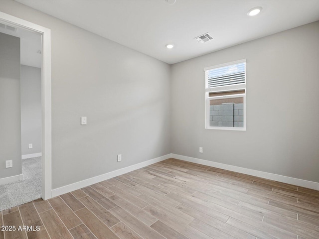 spare room with recessed lighting, visible vents, baseboards, and wood finished floors