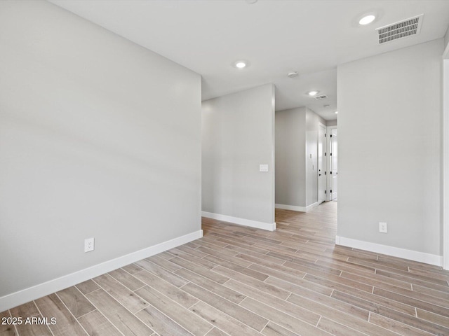 spare room with recessed lighting, baseboards, visible vents, and wood finish floors