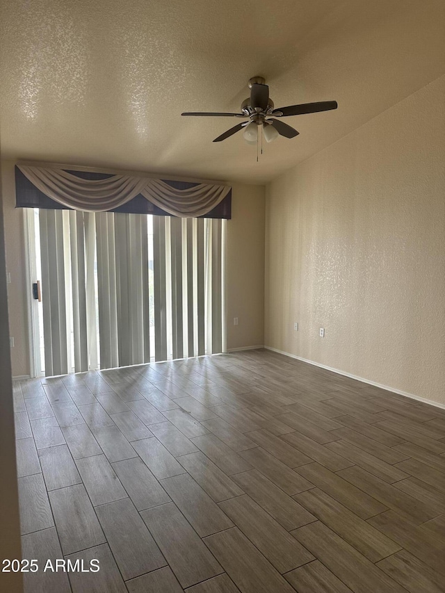 spare room with wood finish floors, a textured ceiling, ceiling fan, and a textured wall