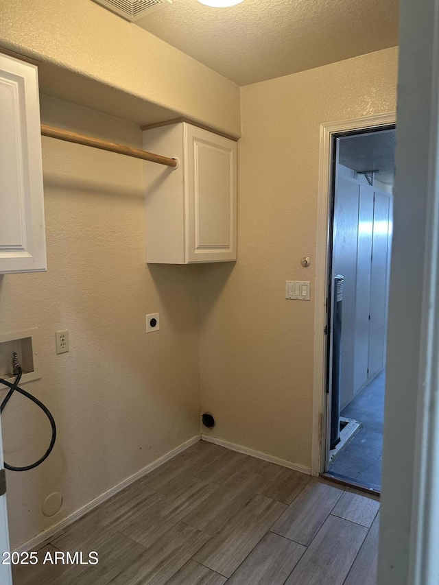 laundry room featuring dark wood-style floors, cabinet space, hookup for a washing machine, and baseboards