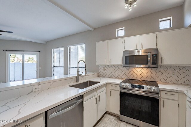 kitchen featuring white cabinetry, sink, backsplash, and stainless steel appliances