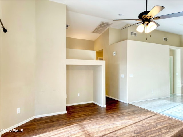 empty room featuring ceiling fan, high vaulted ceiling, and wood-type flooring