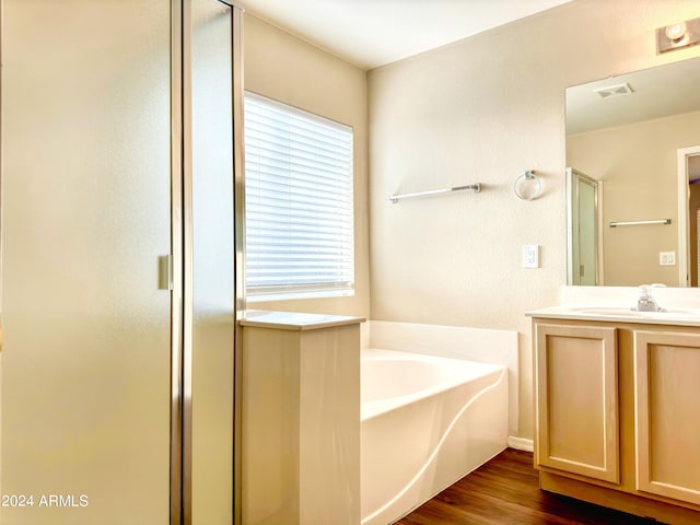 bathroom with vanity, independent shower and bath, and hardwood / wood-style flooring