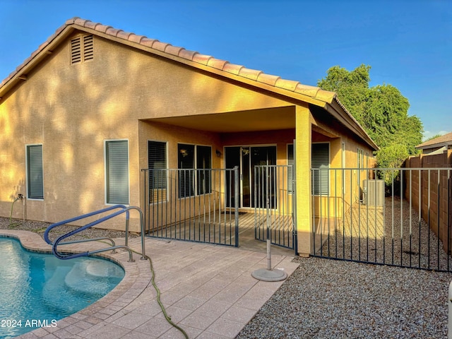 back of house with a fenced in pool, a patio, and central AC unit