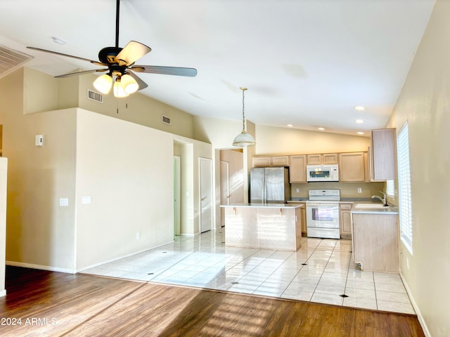 kitchen featuring white appliances, vaulted ceiling, light brown cabinets, light hardwood / wood-style floors, and a kitchen island