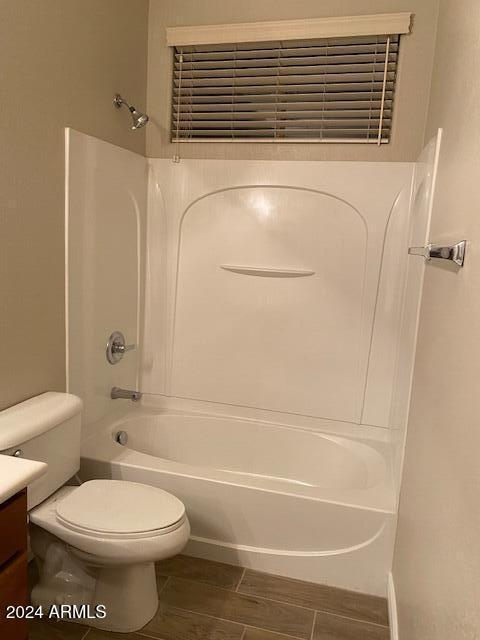 full bathroom featuring bathtub / shower combination, wood-type flooring, vanity, and toilet