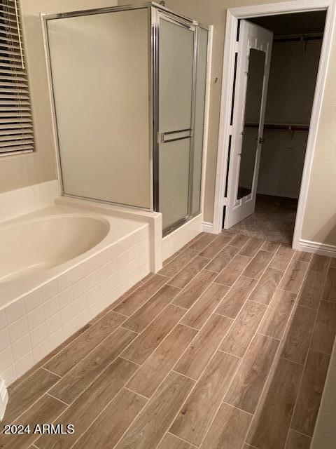 bathroom featuring separate shower and tub and hardwood / wood-style flooring