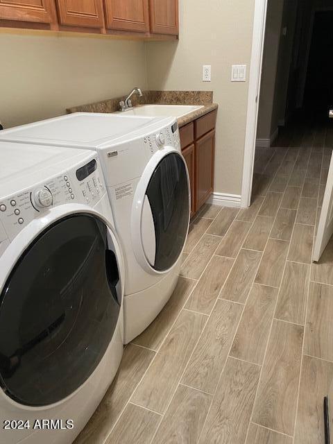 laundry room featuring cabinets, sink, and washing machine and clothes dryer