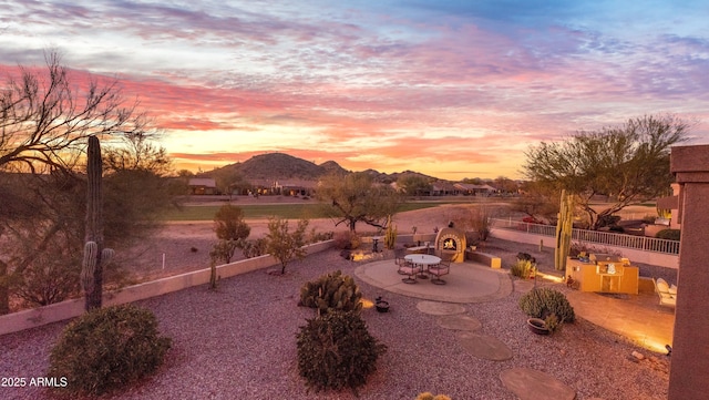 yard at dusk with a mountain view and a patio