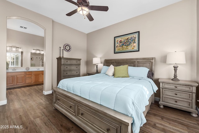 bedroom featuring sink, dark wood-type flooring, connected bathroom, and ceiling fan