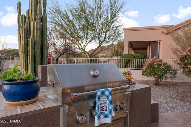 view of patio / terrace featuring exterior kitchen and a grill