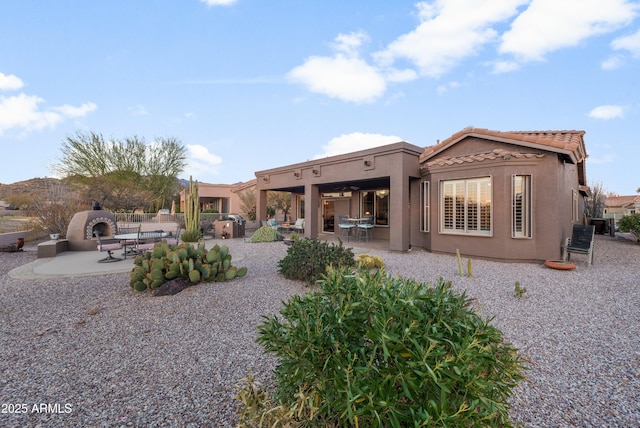 rear view of house featuring a patio and a fireplace