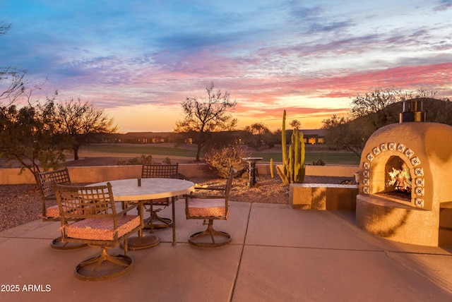 patio terrace at dusk with exterior fireplace