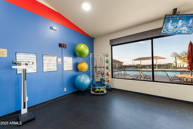 workout room with a water view and vaulted ceiling