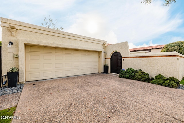 view of front of property with a garage, driveway, and stucco siding