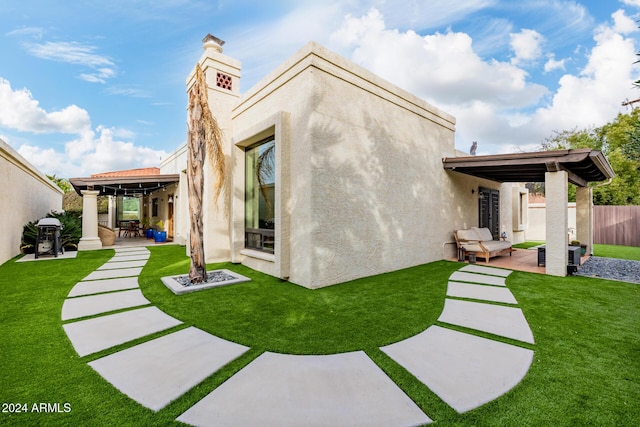 rear view of house featuring a yard and a patio