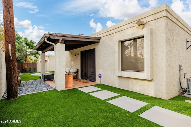 rear view of property featuring a patio and a lawn