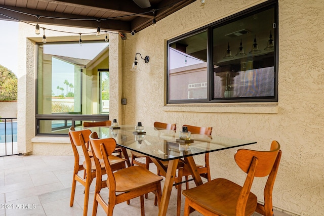 dining space featuring beam ceiling, light tile patterned flooring, wooden ceiling, and a wealth of natural light