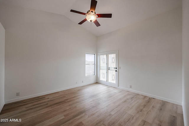 empty room with ceiling fan, high vaulted ceiling, light wood-type flooring, and baseboards