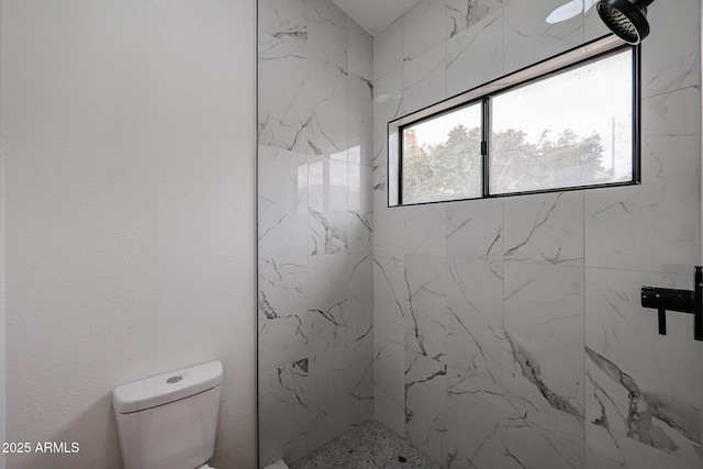 bathroom featuring toilet and tiled shower