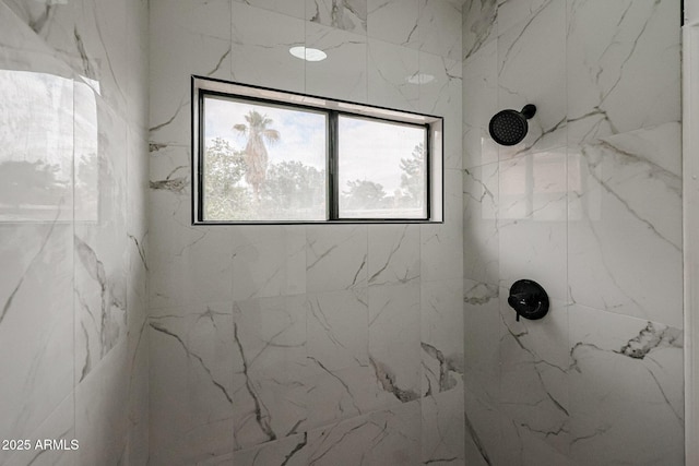 bathroom featuring a marble finish shower