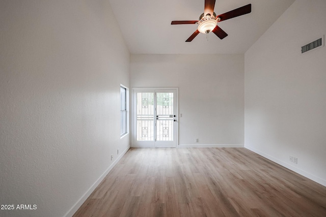 unfurnished room with a ceiling fan, light wood-type flooring, visible vents, and baseboards